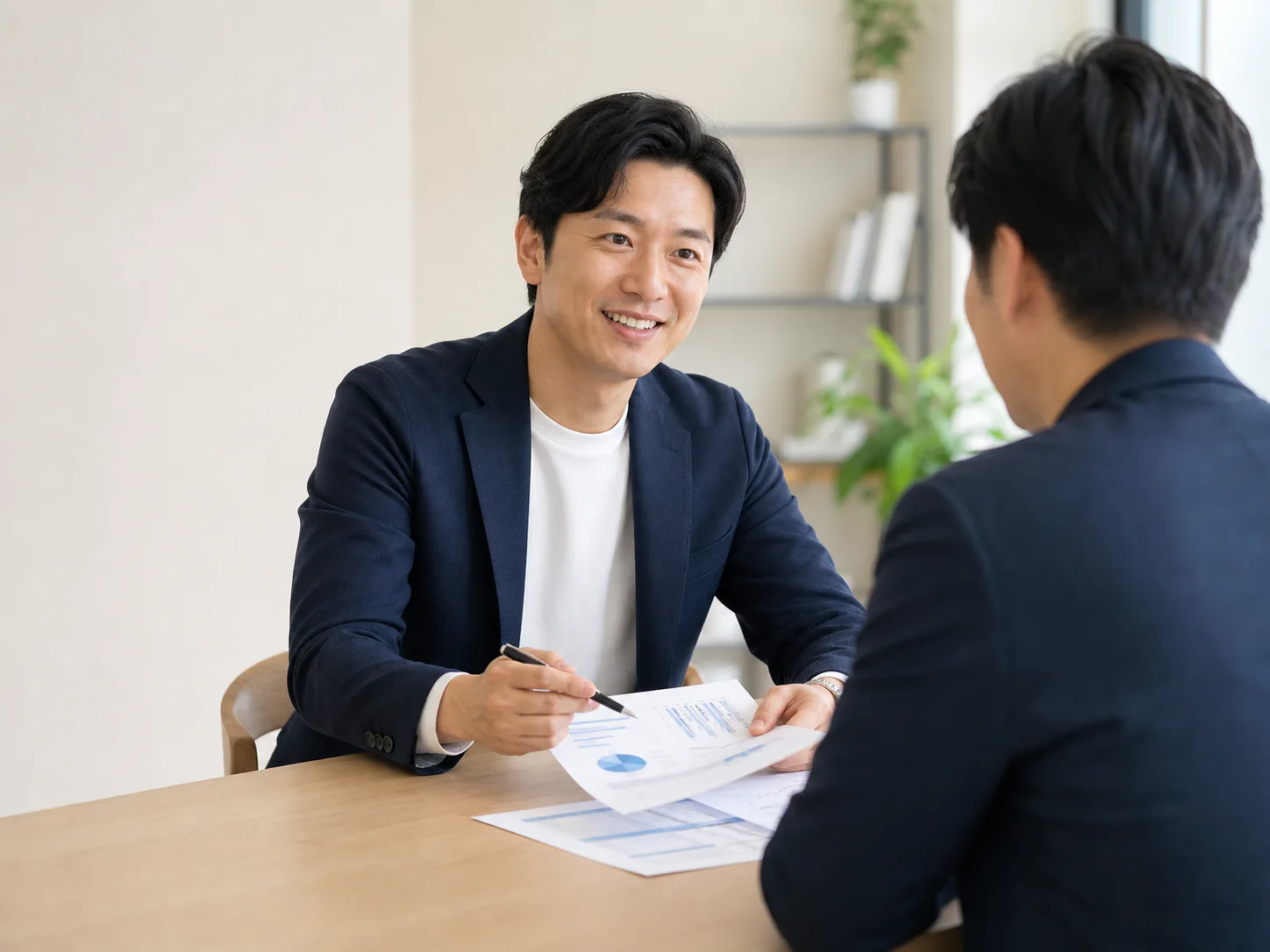 경영 전문가가 대표와 마주 앉아 사업 자료를 함께 검토하는 모습
